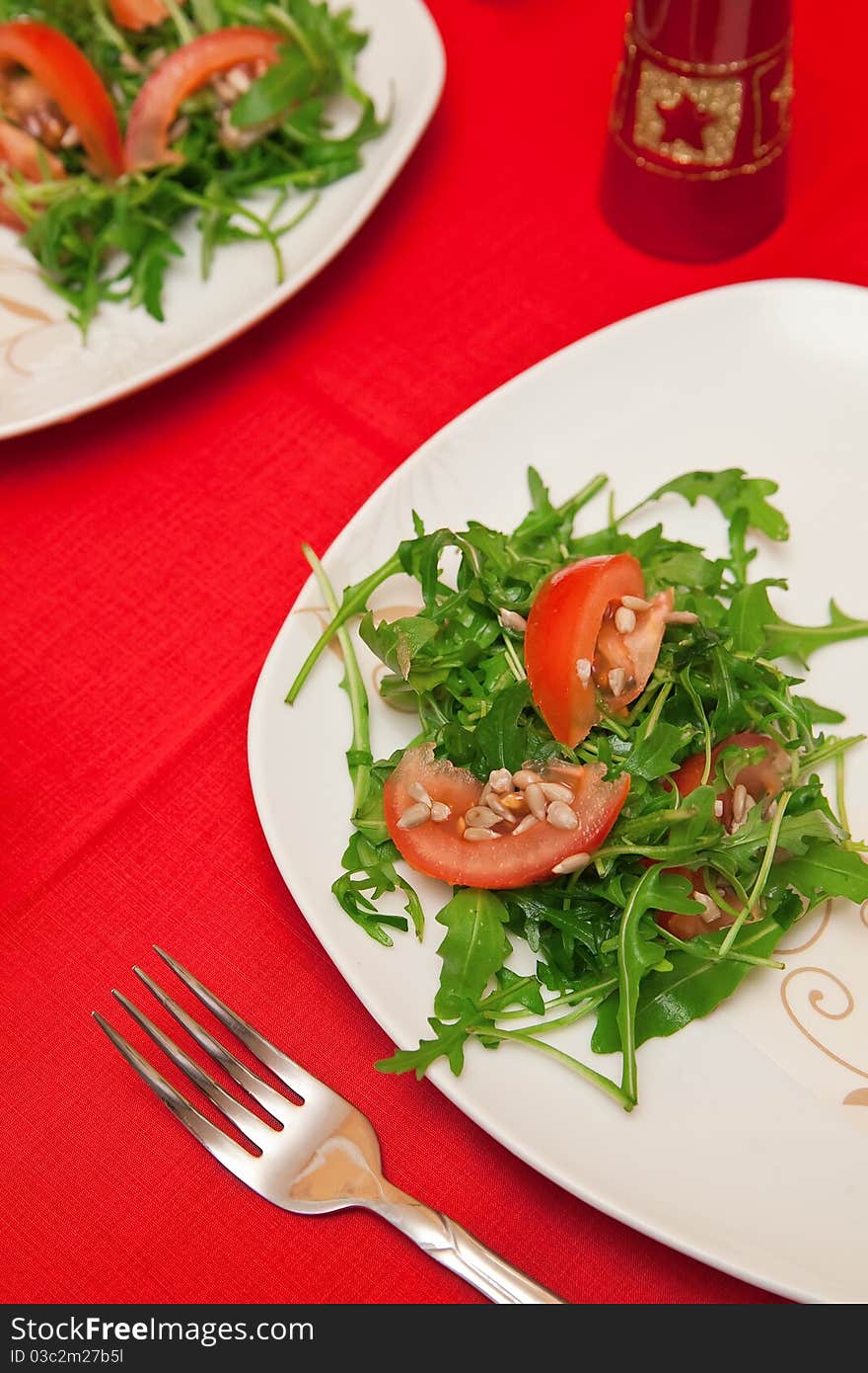 Green salad made of ruccola leaves, tomatoes and sunflower seeds. Green salad made of ruccola leaves, tomatoes and sunflower seeds