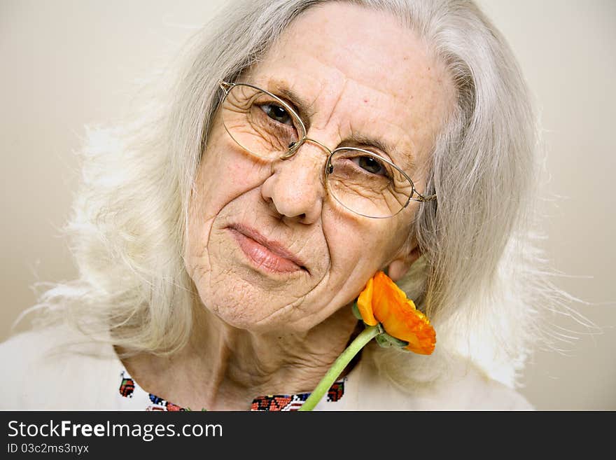 Beautiful senior woman with orange flower. Beautiful senior woman with orange flower