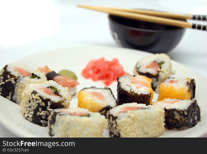 On a plate there is a land, on a background a bowl with soya sauce. On a plate there is a land, on a background a bowl with soya sauce.