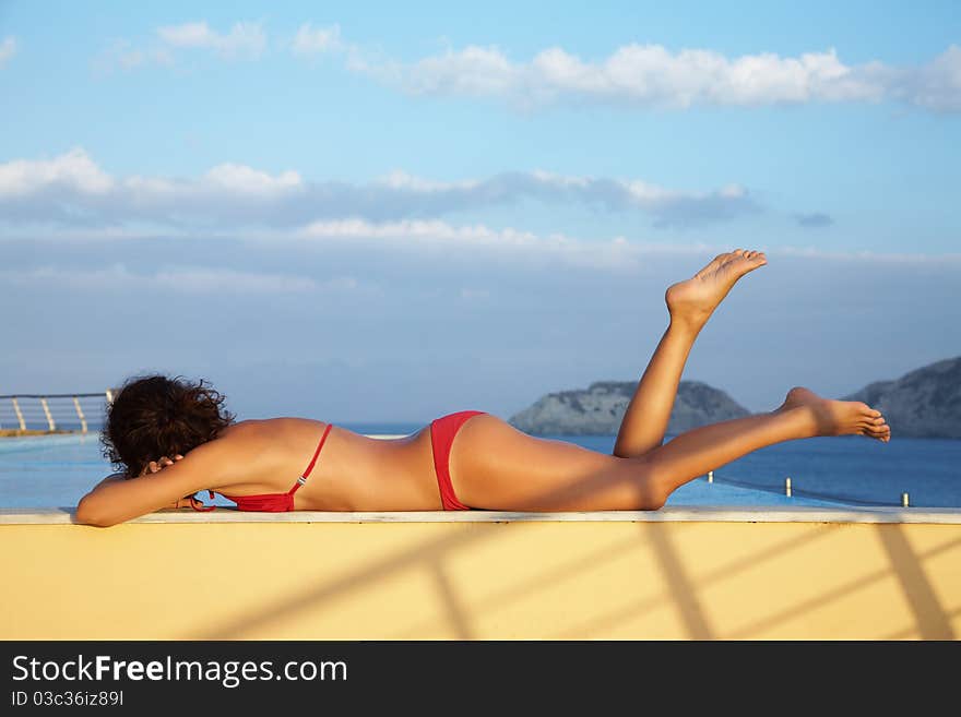 Beautiful slim  girl sunning at the pool. Beautiful slim  girl sunning at the pool