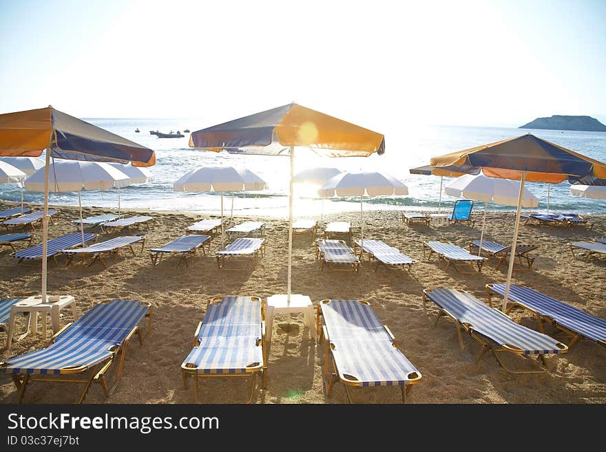 Photo free deck-chairs on seashore with water near by in summer. Photo free deck-chairs on seashore with water near by in summer