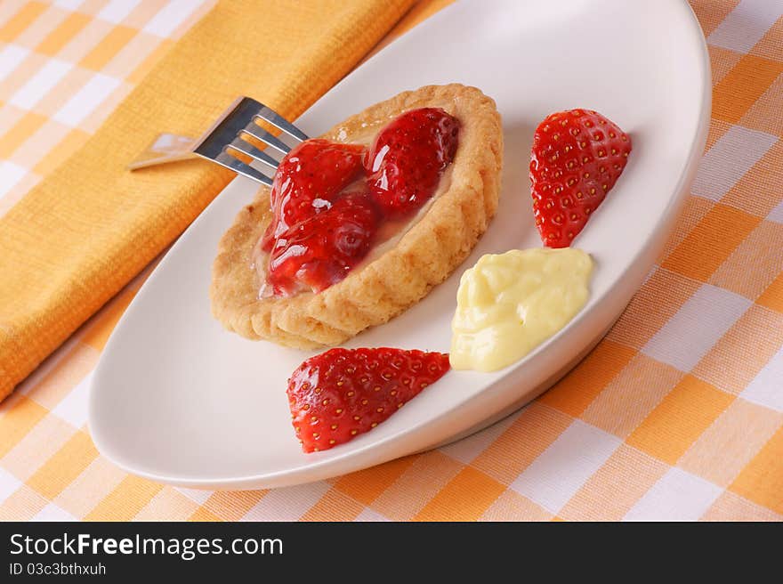 Strawberry tart with custard served on a white dish