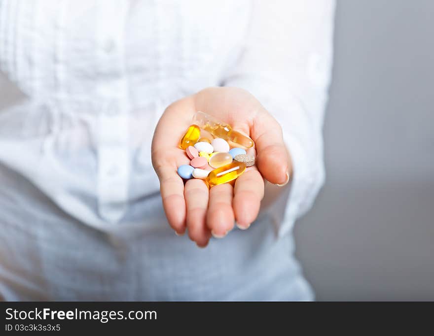 Woman holding pharmaceuticals on neutral bg. Woman holding pharmaceuticals on neutral bg