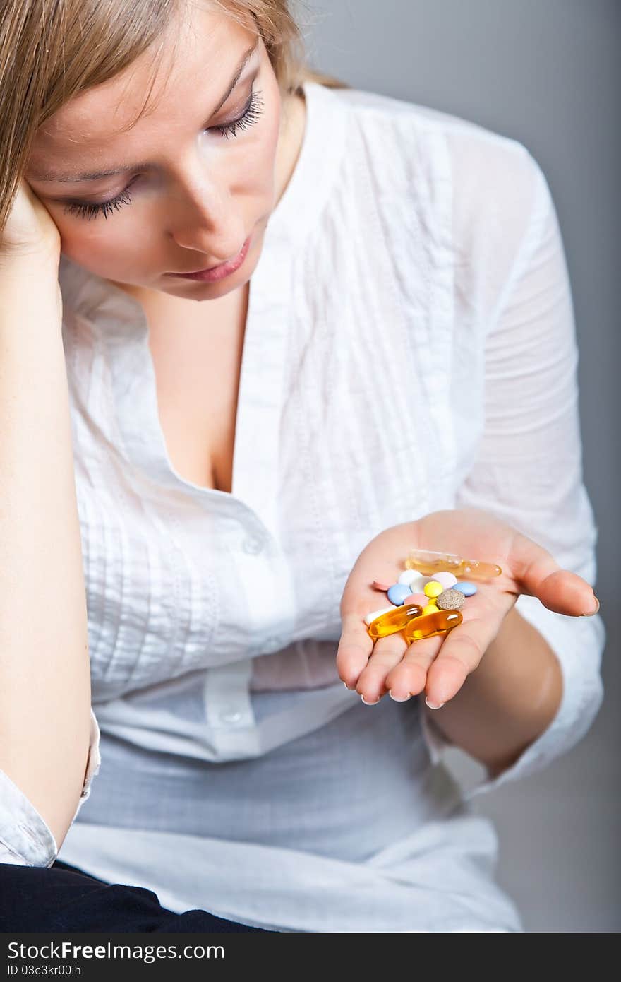 Woman holding pharmaceuticals on neutral bg. Woman holding pharmaceuticals on neutral bg