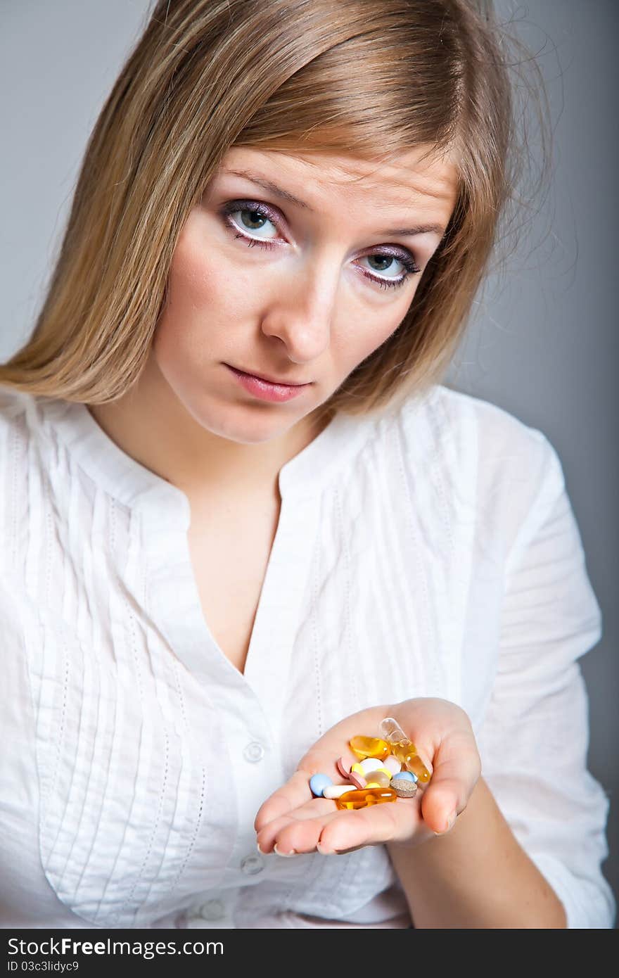 Woman holding pharmaceuticals on neutral bg. Woman holding pharmaceuticals on neutral bg