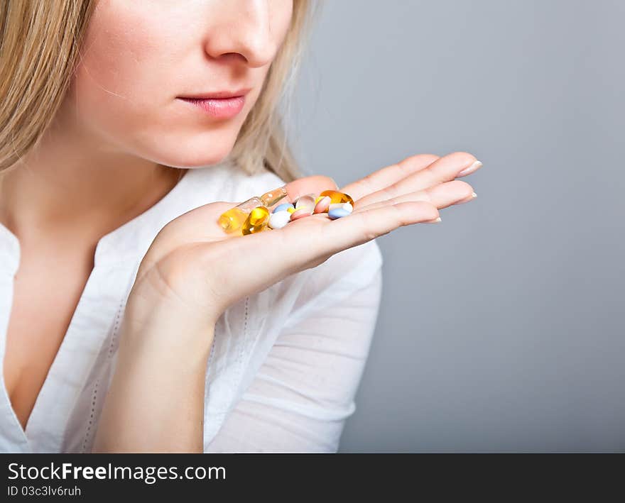 Woman holding pharmaceuticals on neutral bg. Woman holding pharmaceuticals on neutral bg