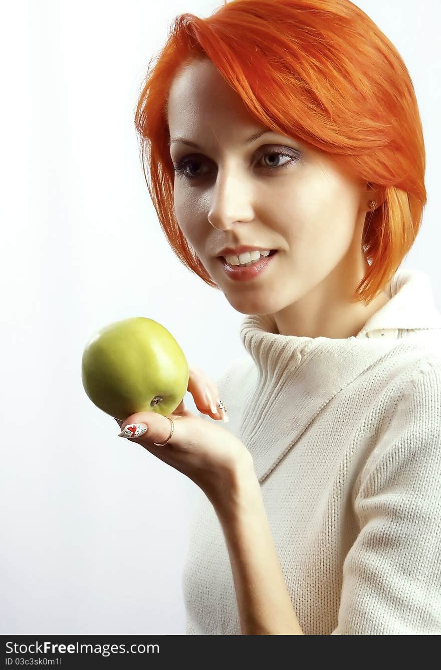 The beautiful woman with an apple in a hand on a white background