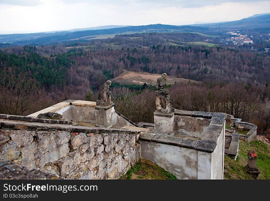 Ruined stairs with statues and European countryside during the autumn time.