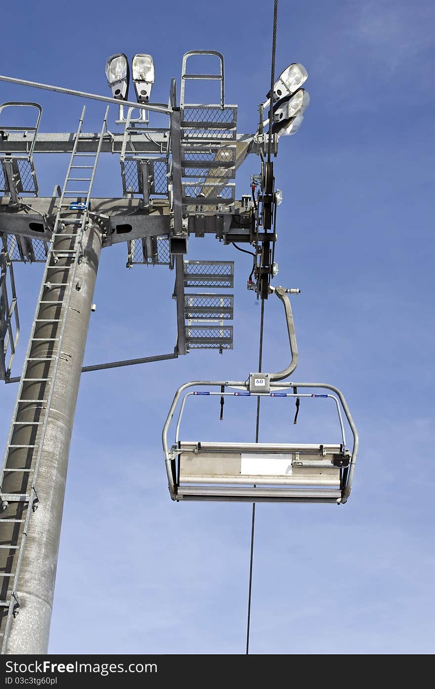 Ski chairlift tower on a blue sky.