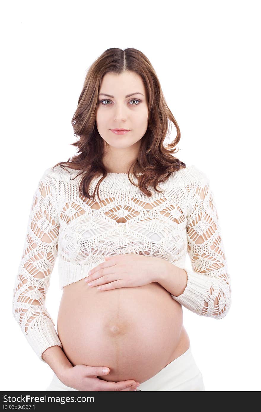 Studio portrait of pregnant woman holding her belly with hands