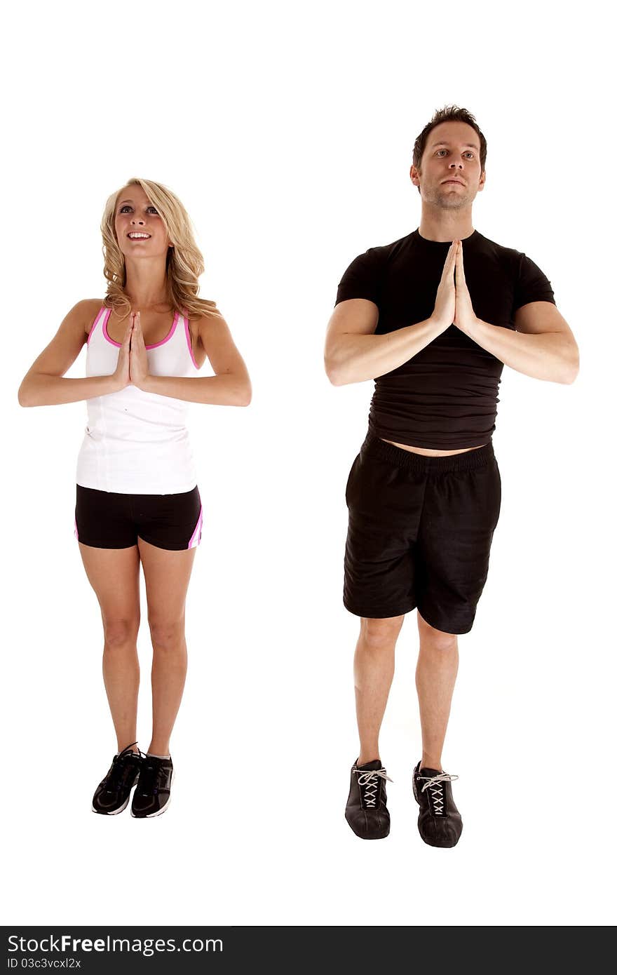 A man and woman standing side by side doing a standing yoga pose. A man and woman standing side by side doing a standing yoga pose.