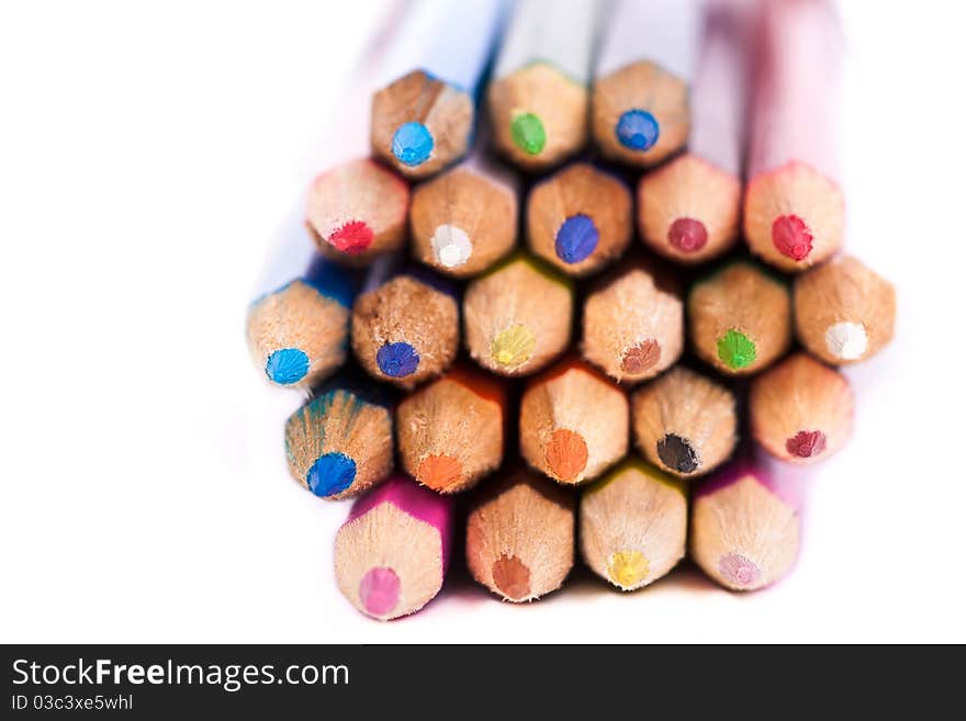 Bunch of colored pencils across white