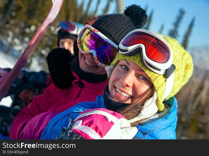 Snowboarders on the chairlift smile for the camera