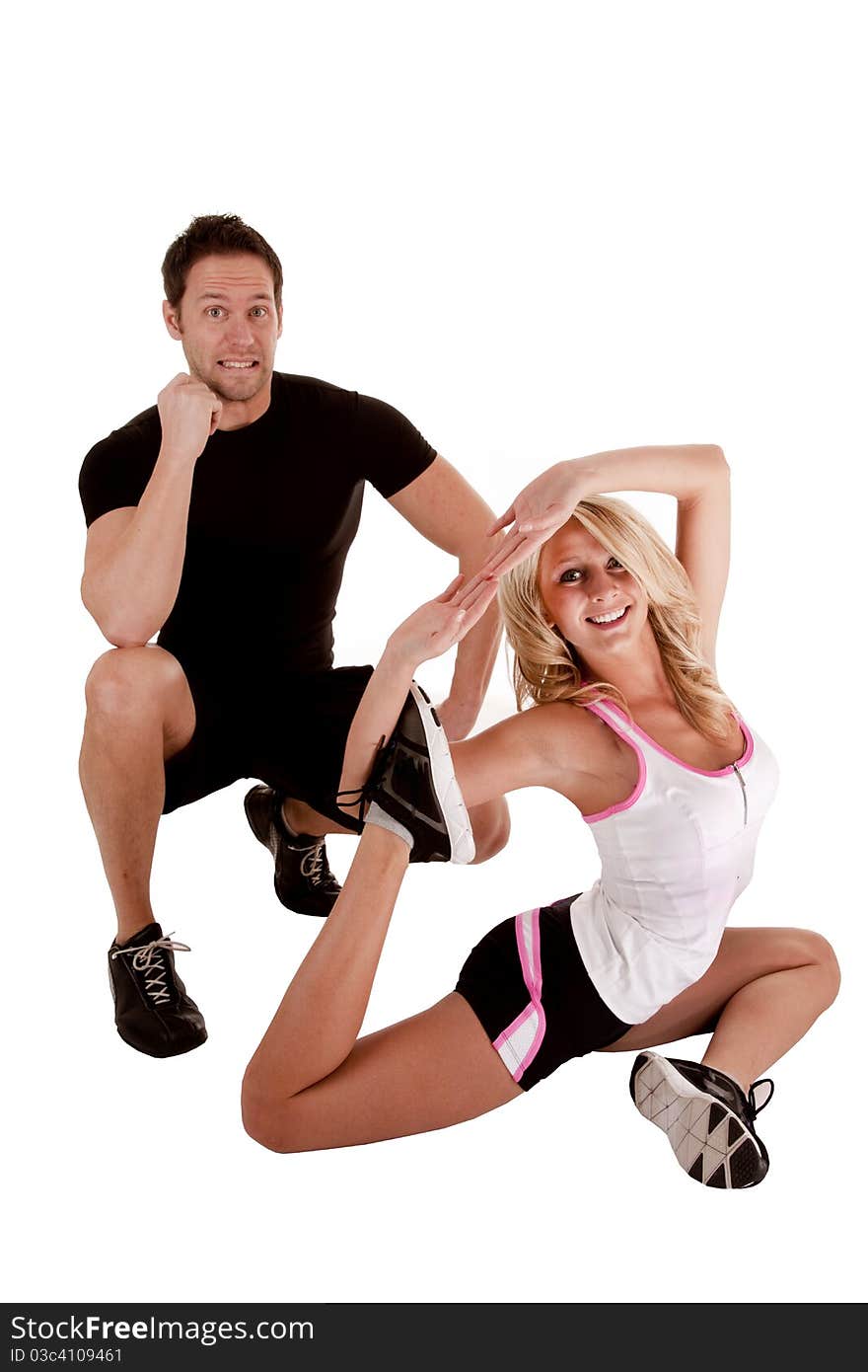 A man giving a shocked expression while a woman is doing a stretch. A man giving a shocked expression while a woman is doing a stretch.