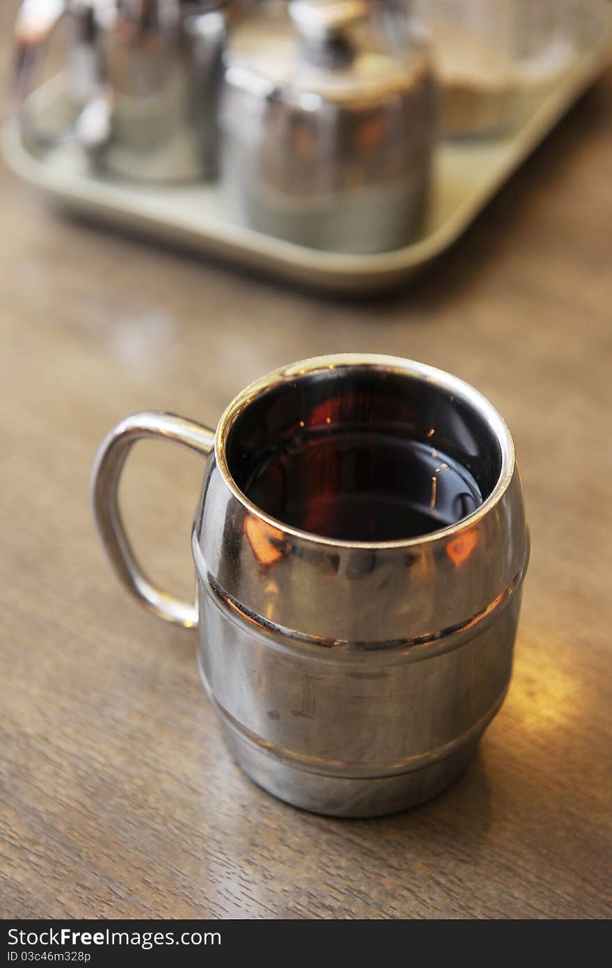 A cup of tea on table,the cup is made by metal.