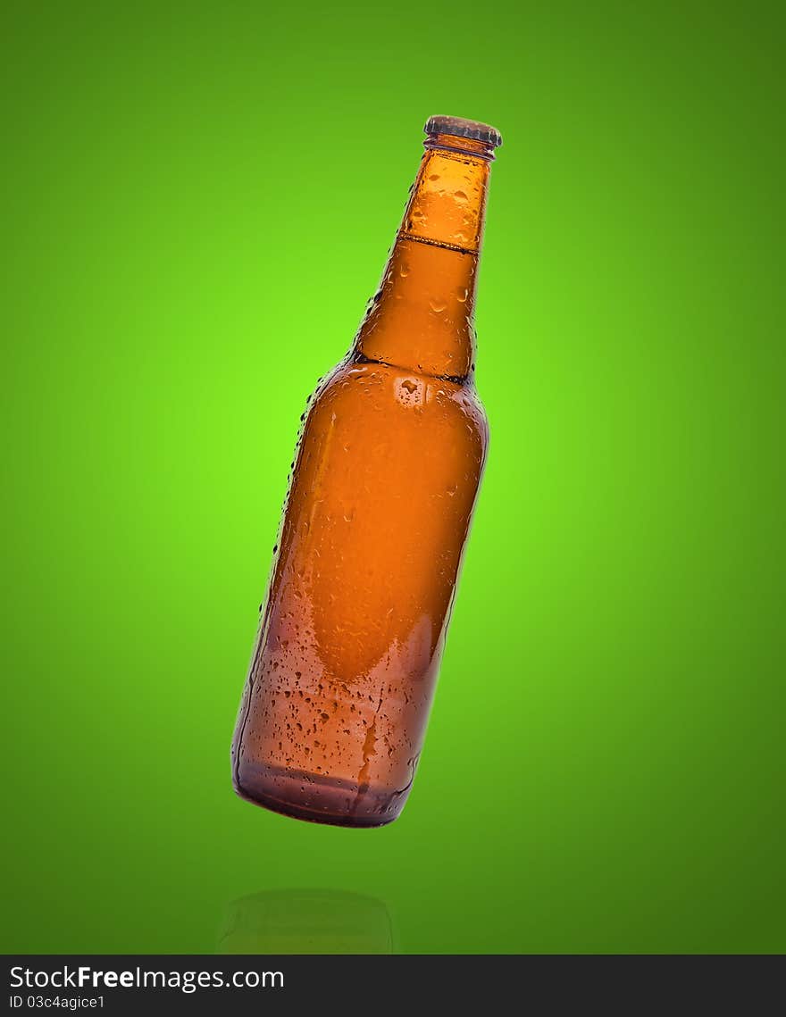 Dark bottle of beer on a green background