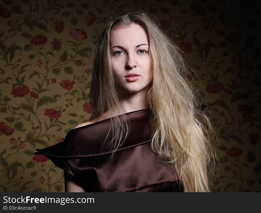 Portrait of the beauty young blond girl near the wall with roses. Portrait of the beauty young blond girl near the wall with roses