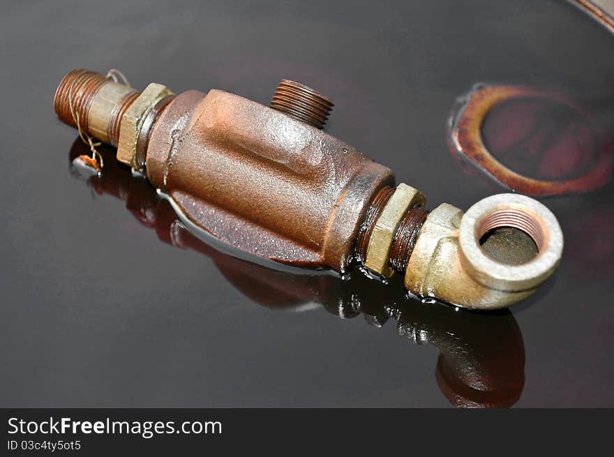 An Oil fitting on a barrel in oil