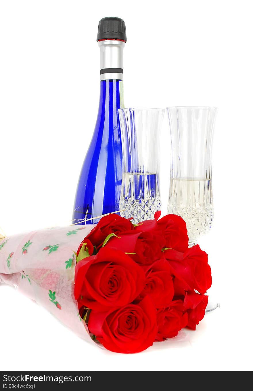 Champagne and roses for celebration of Valentines day with blue bottle in background