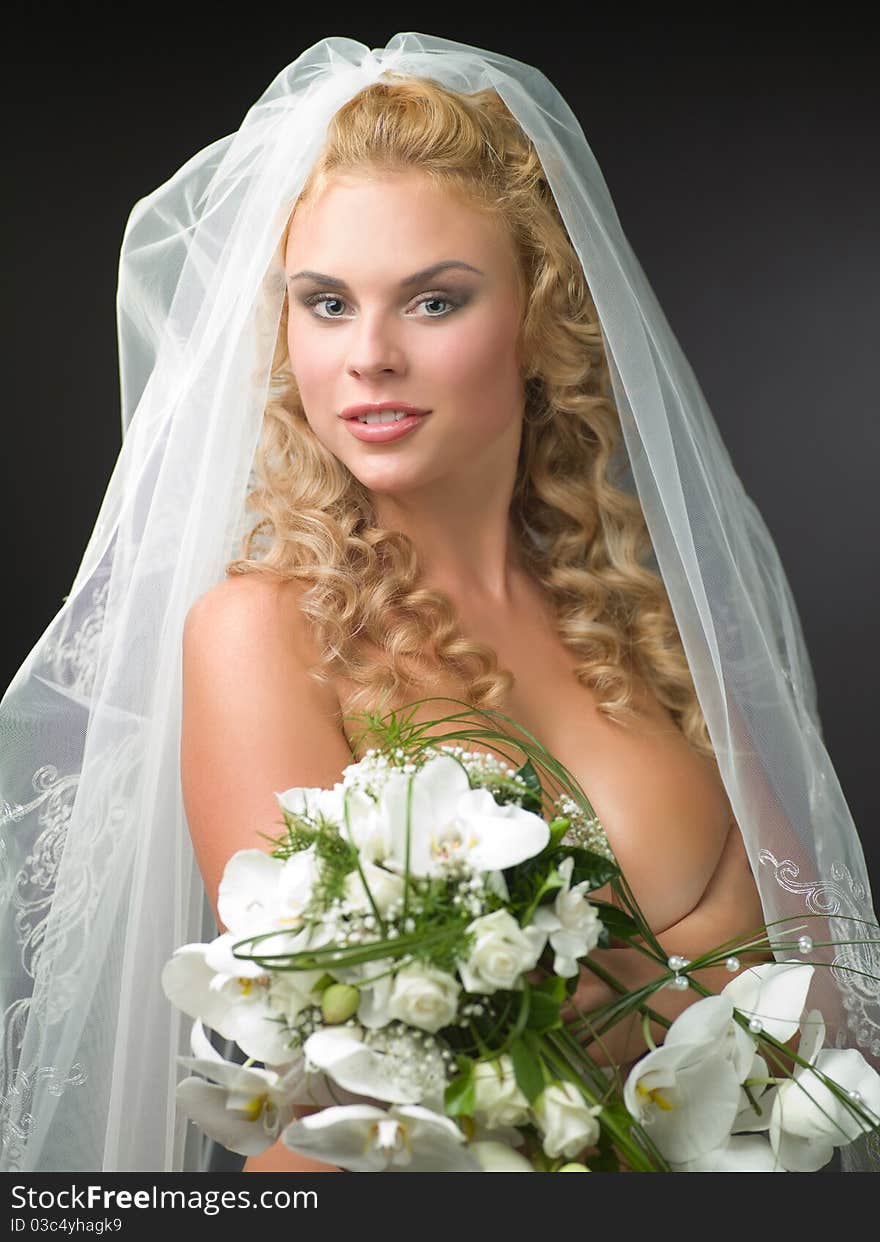 Woman in a veil bride with a bouquet of flowers