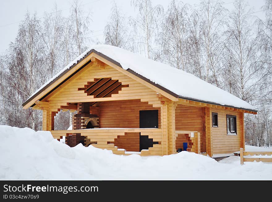 Ecological wooden house where warm even in cold, snowy winter, covered practical linseed oil, with beautiful glass windows and a fireplace in the open part of the structure. Ecological wooden house where warm even in cold, snowy winter, covered practical linseed oil, with beautiful glass windows and a fireplace in the open part of the structure