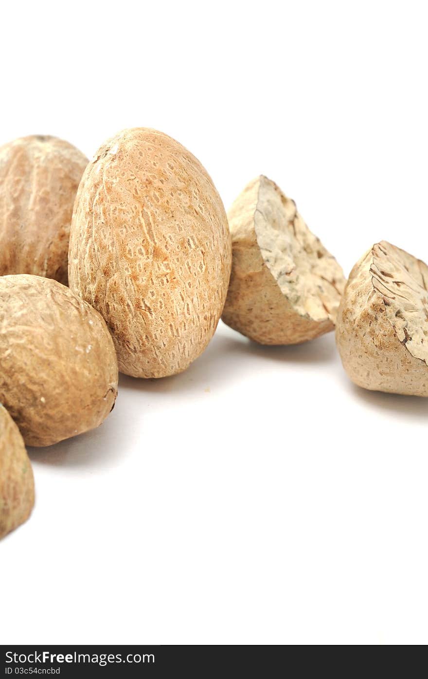 A close-up shot of nutmegs on a white background. A close-up shot of nutmegs on a white background