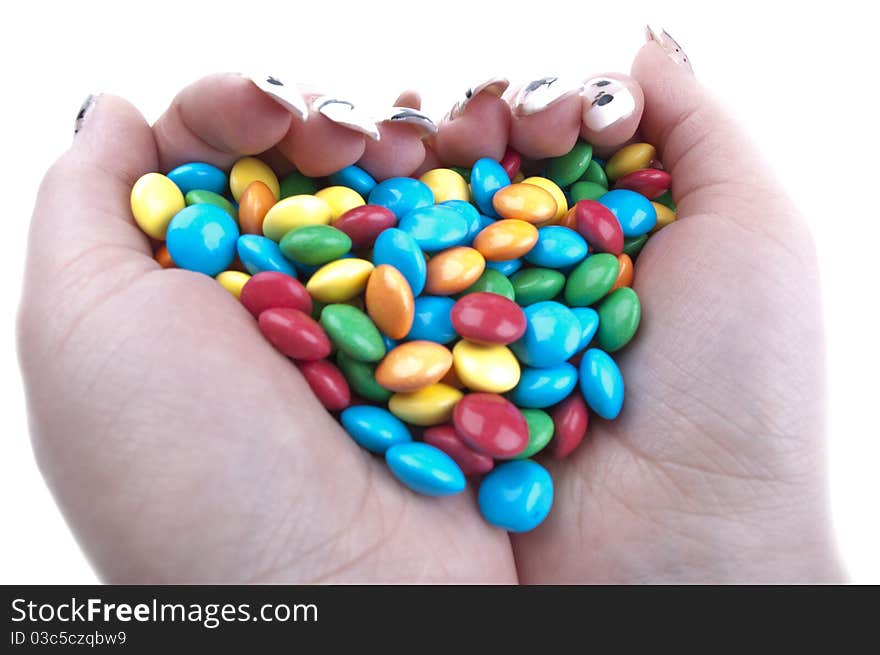 Colored candies in hands isolated on a white background