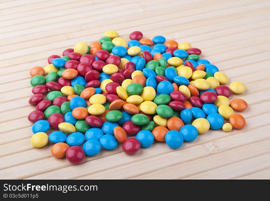 Many colored candy on a wooden table. Many colored candy on a wooden table