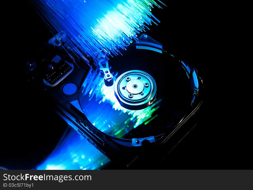 Hard disc with fiber optics background. Studio shot