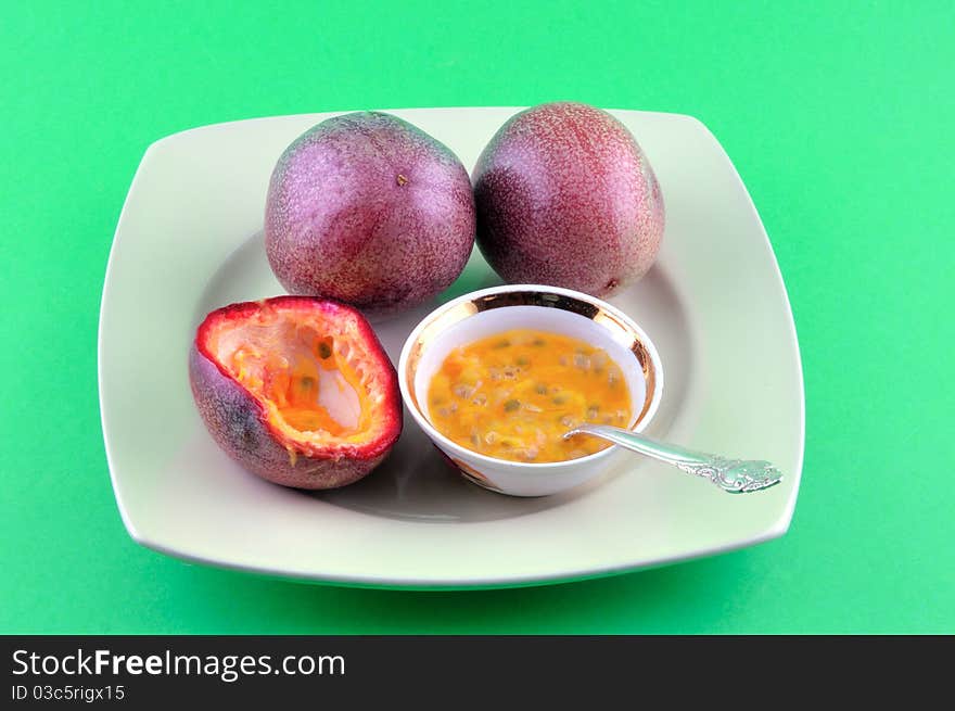 Two ripe fruit Ginger lie on the plate, and the contents of the third in a small bowl. Two ripe fruit Ginger lie on the plate, and the contents of the third in a small bowl