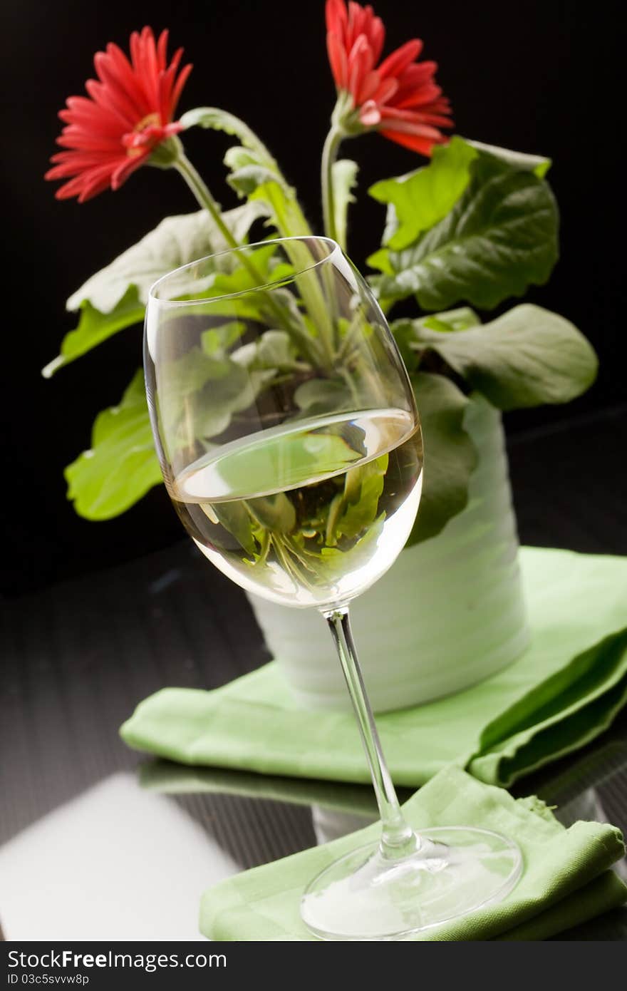 Photo of calyx with white wine and red flower in the background