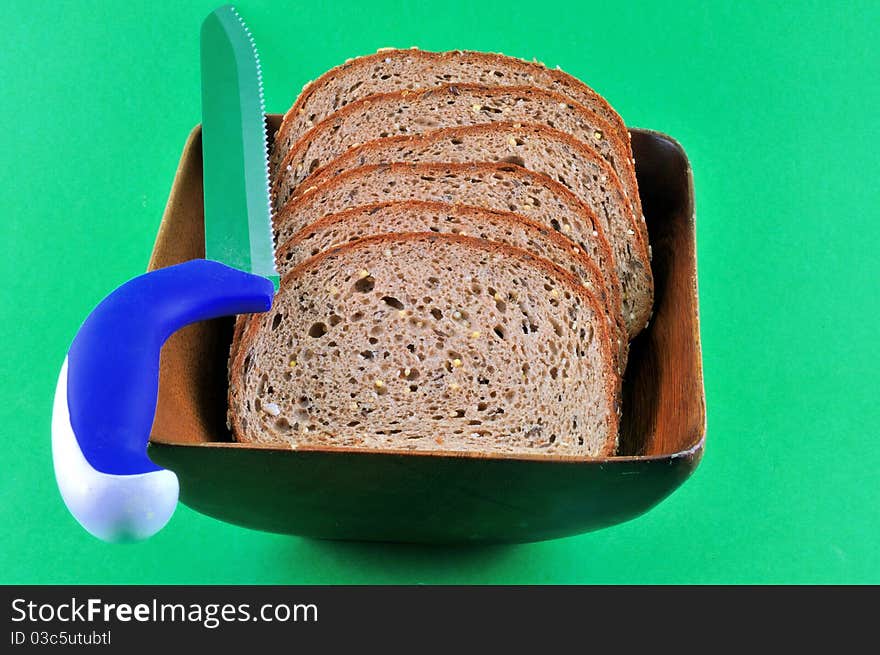 Black rye bread cut into slices lying in a wooden platter. Black rye bread cut into slices lying in a wooden platter