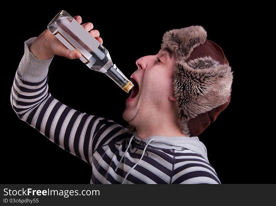 Man in a striped sweater and a fur hat with the bottle of alkohol