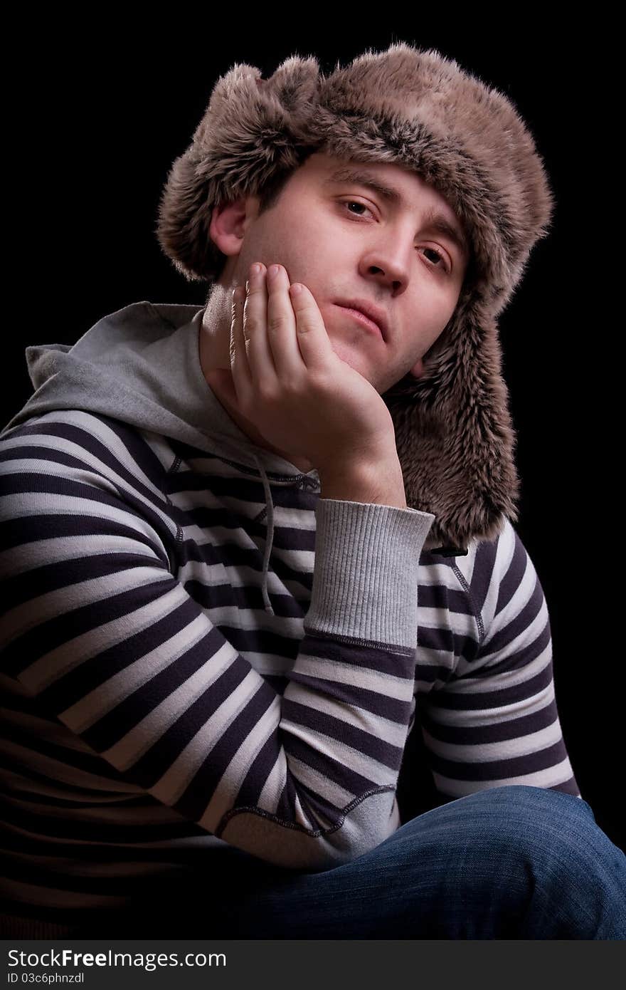 Portrait of man in a striped sweater and a fur hat. Portrait of man in a striped sweater and a fur hat