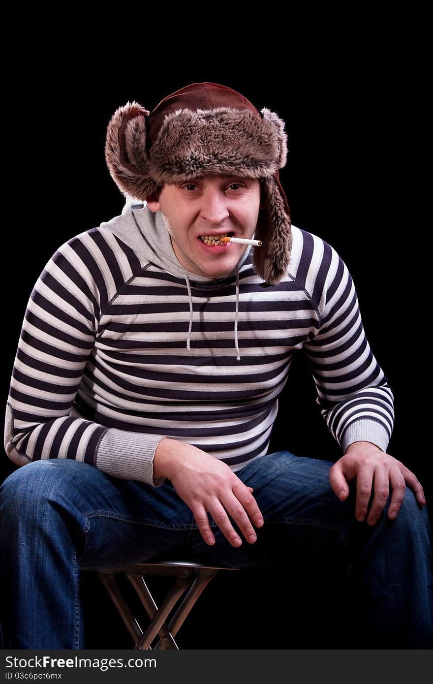 Emotional portrait of a man in a striped sweater and a fur hat