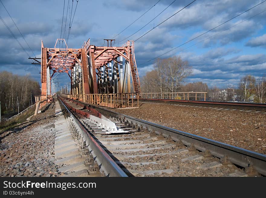 The railway bridge both passing on it and rails leaving in a distance