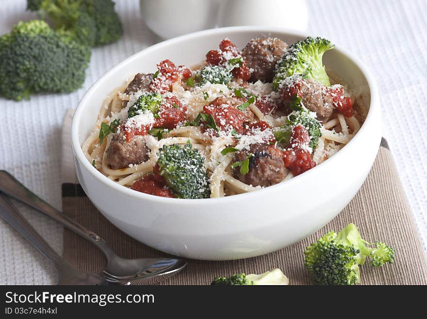 Beef meatballs with spaghetti and broccoli topped with grated parmesan. Beef meatballs with spaghetti and broccoli topped with grated parmesan