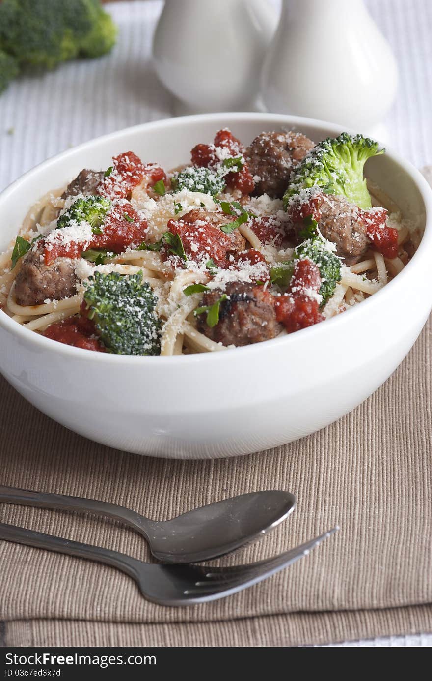 Beef meatballs with spaghetti and broccoli topped with grated parmesan. Beef meatballs with spaghetti and broccoli topped with grated parmesan