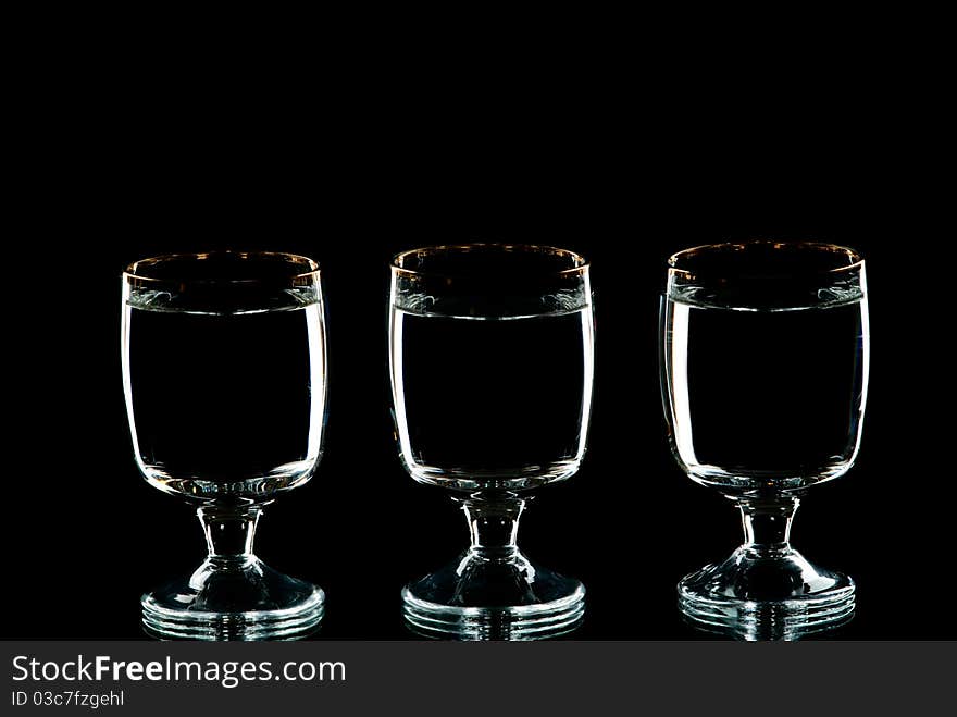 Three wine glasses with alcohol. Black background. Studio shot.