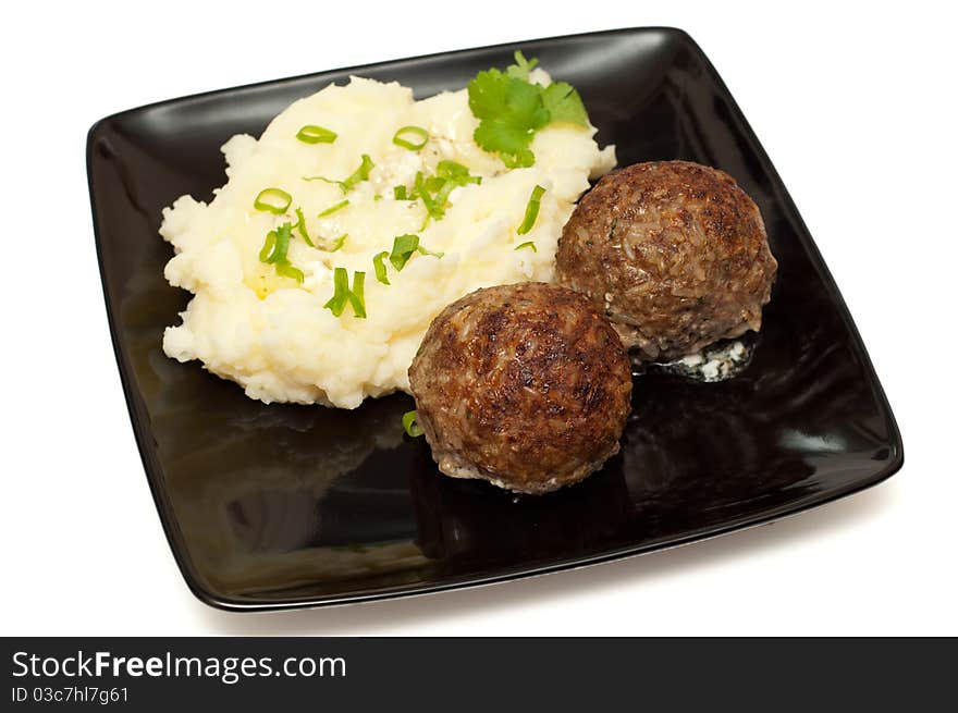 Meatballs with mashed potato on the plate closeup