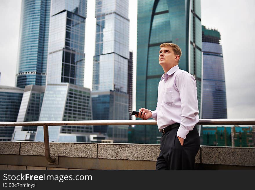 Man with phone against backdrop of city