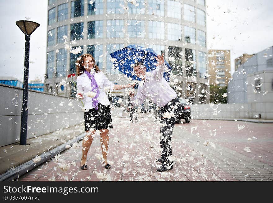 Romantic walk through the town with an umbrella and flying feathers. Romantic walk through the town with an umbrella and flying feathers