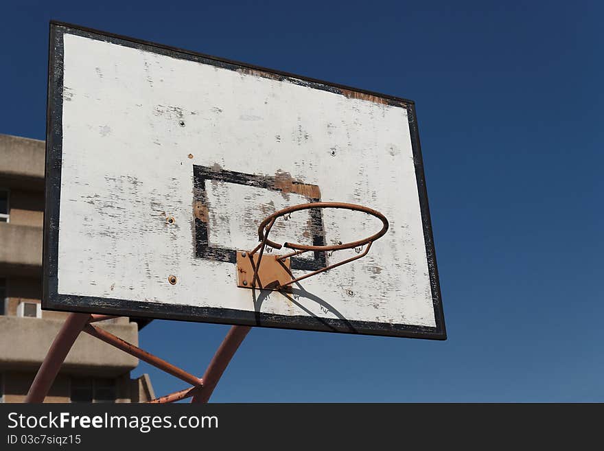 Old broken basketball hoop against the sky