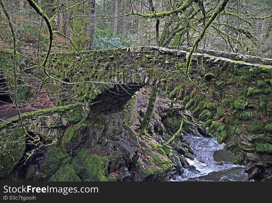 Stone bridge over waterfall in the highlands of scotland in winter