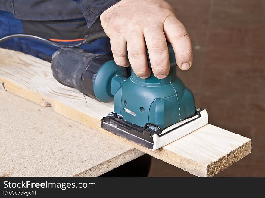 A man working with electrical sanding machine, close up on tool, hands and sparks, real situation picture. A man working with electrical sanding machine, close up on tool, hands and sparks, real situation picture