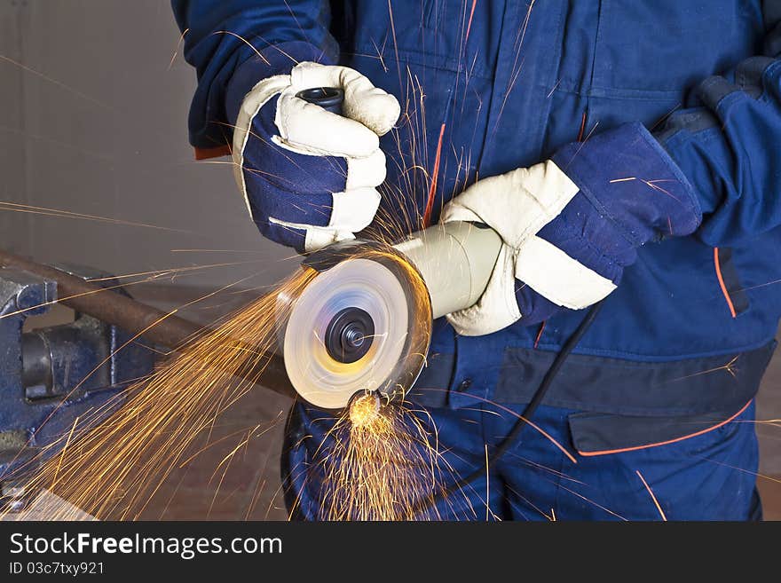 A man working with grinder, close up on tool, hands and sparks, real situation picture. A man working with grinder, close up on tool, hands and sparks, real situation picture