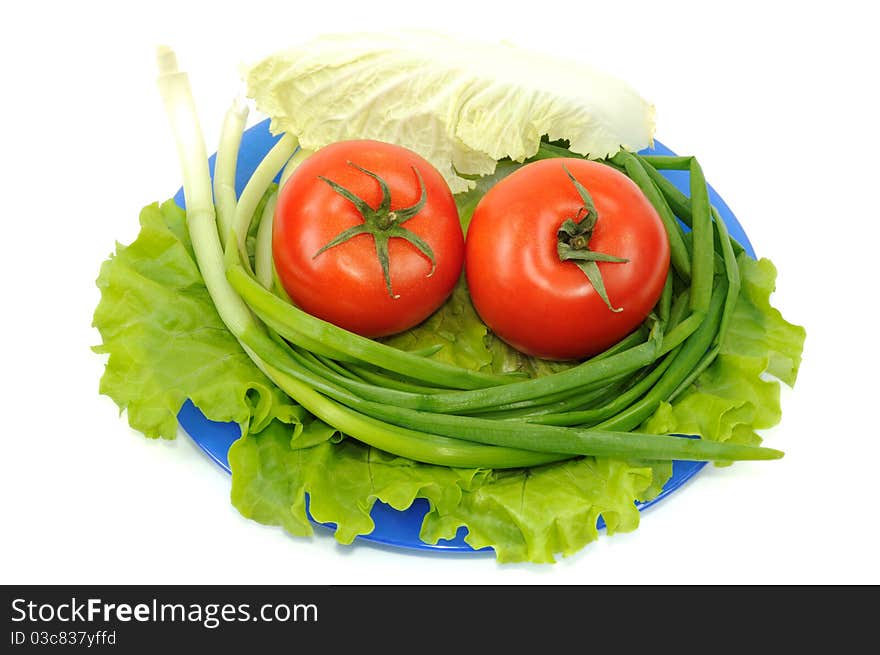 Vegetables on blue plate, isolated on a white background. Vegetables on blue plate, isolated on a white background