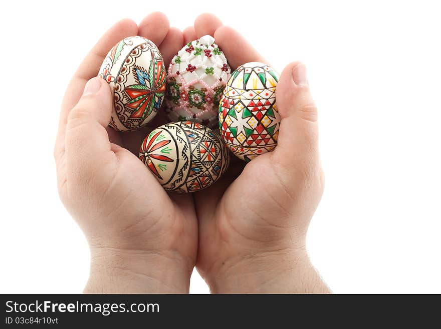 Traditional easter eggs from Transylvania holded in hands with care, isolated on white background