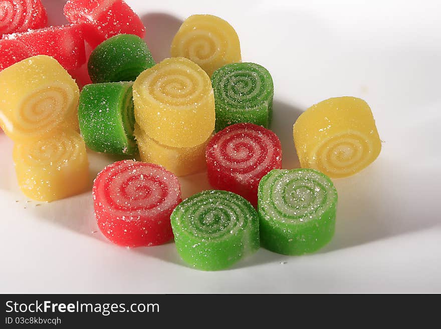 Colorful marmalade rolls on white background.