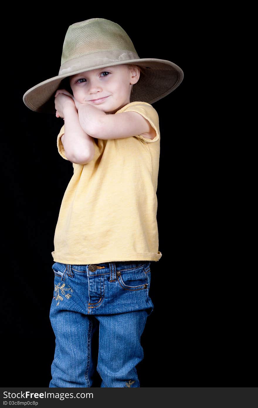 A girl with an oversized hat on. Her arms and hands are clasped behind her head as if she is holding something back or hiding something. A girl with an oversized hat on. Her arms and hands are clasped behind her head as if she is holding something back or hiding something.